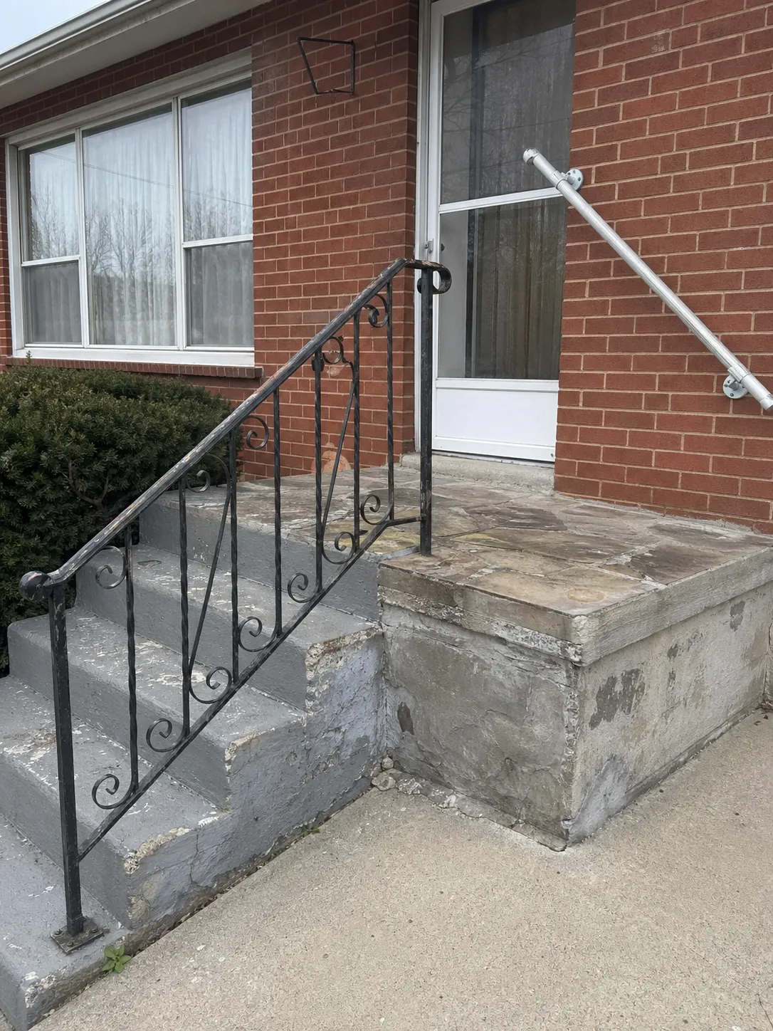 Dated front porch railings with mismatched materials